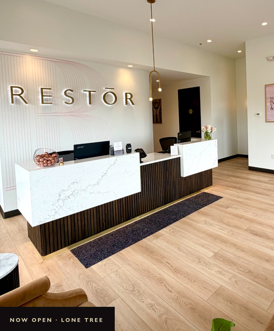RESTOR Lone Tree reception with the illuminated RESTŌR wall sign